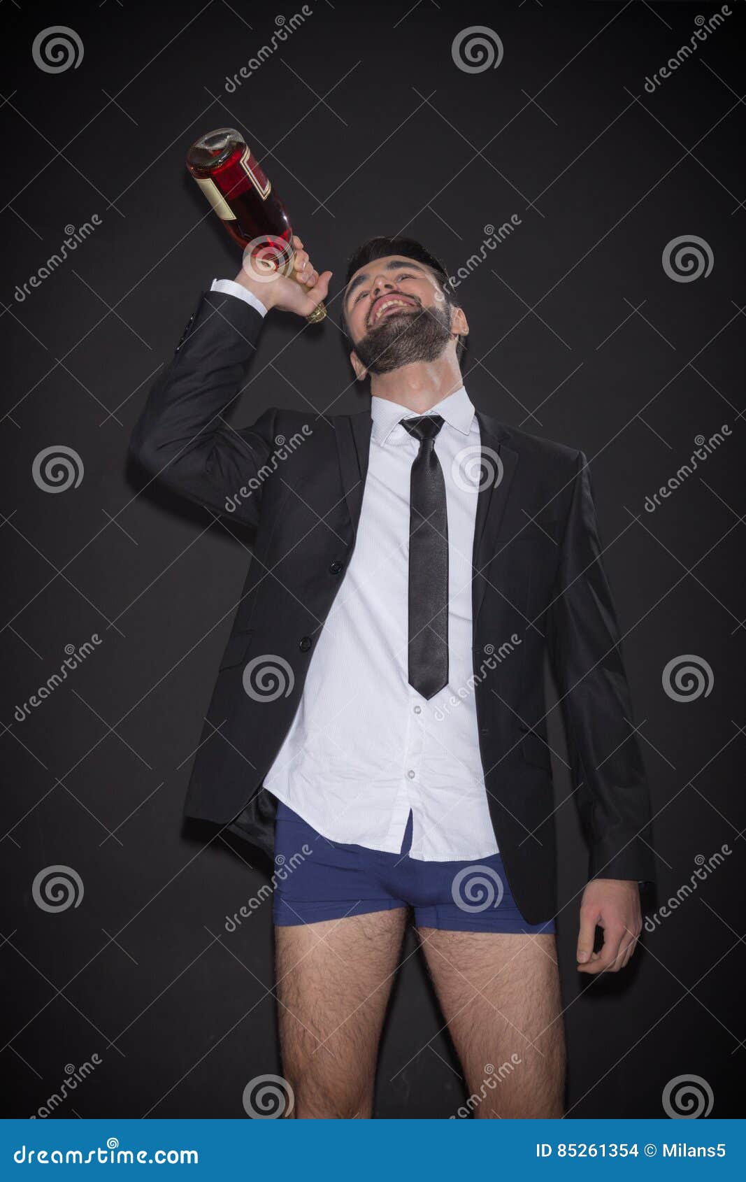 young man bottle alcohol underwear suit legs funny drinking one shirt tie wine black background 85261354