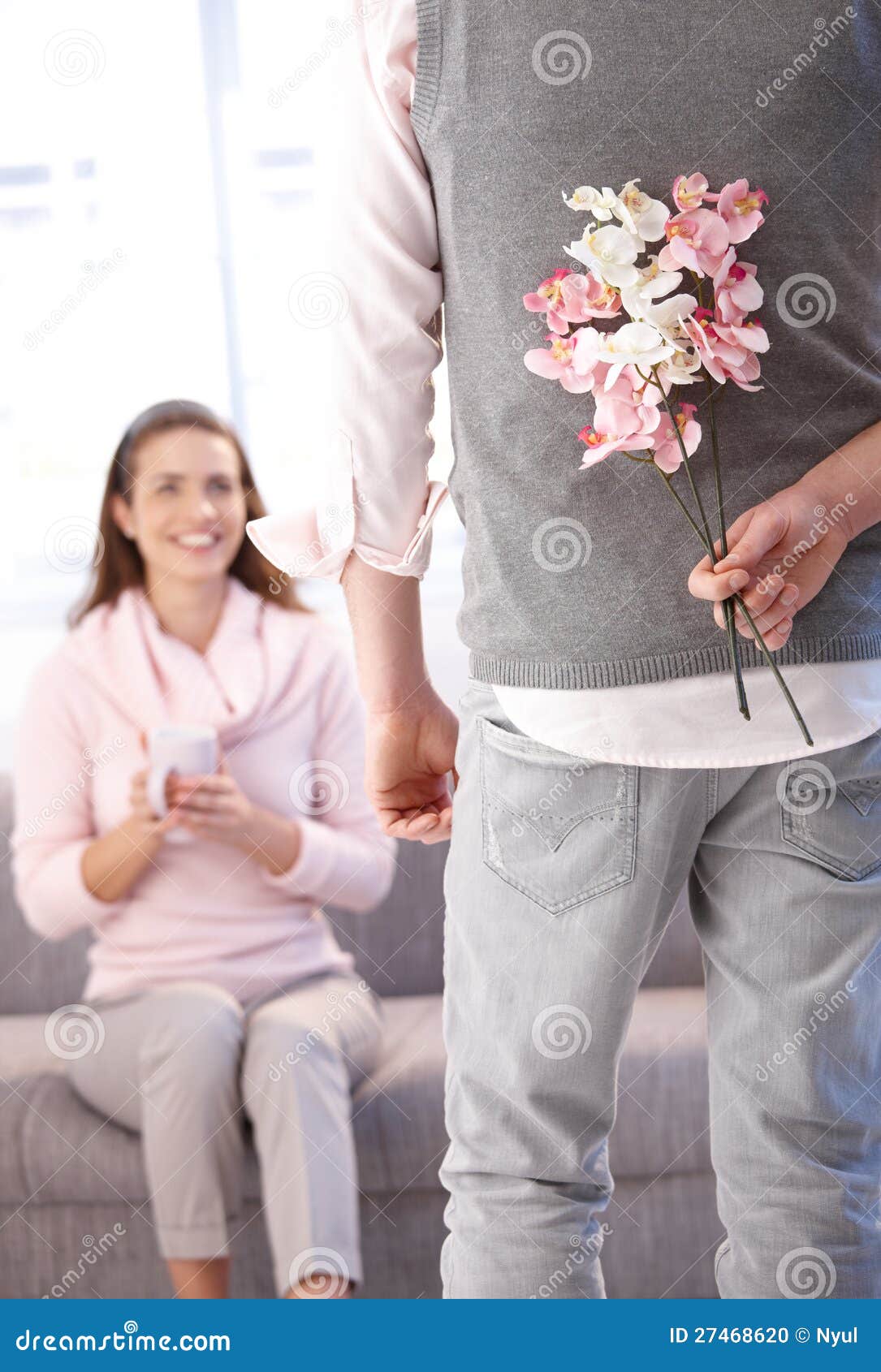 young man bringing flowers to woman