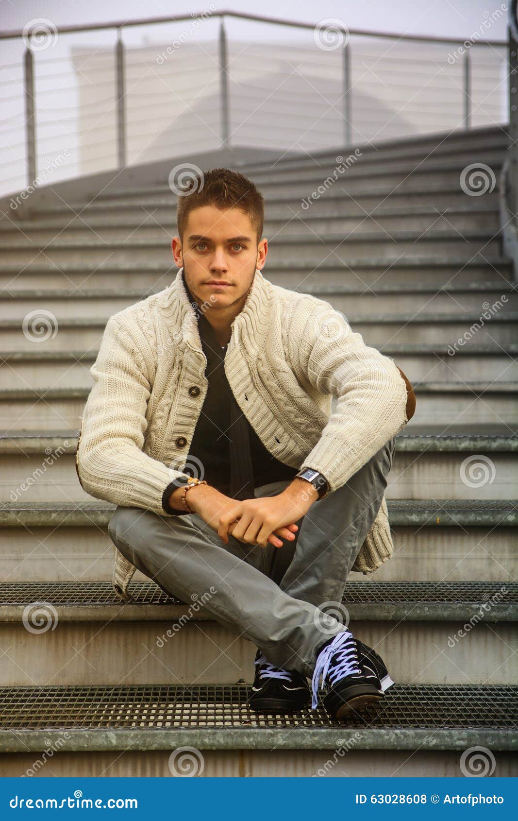 Young Man in Casual Clothes Sitting Cross Legged Stock Photo - Image of ...