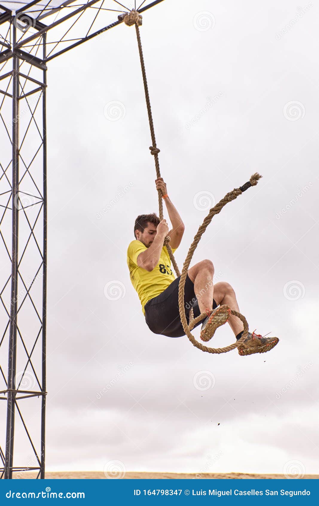 Young Man Climbing a Rope of Knots in a Spartan Race Stock Image