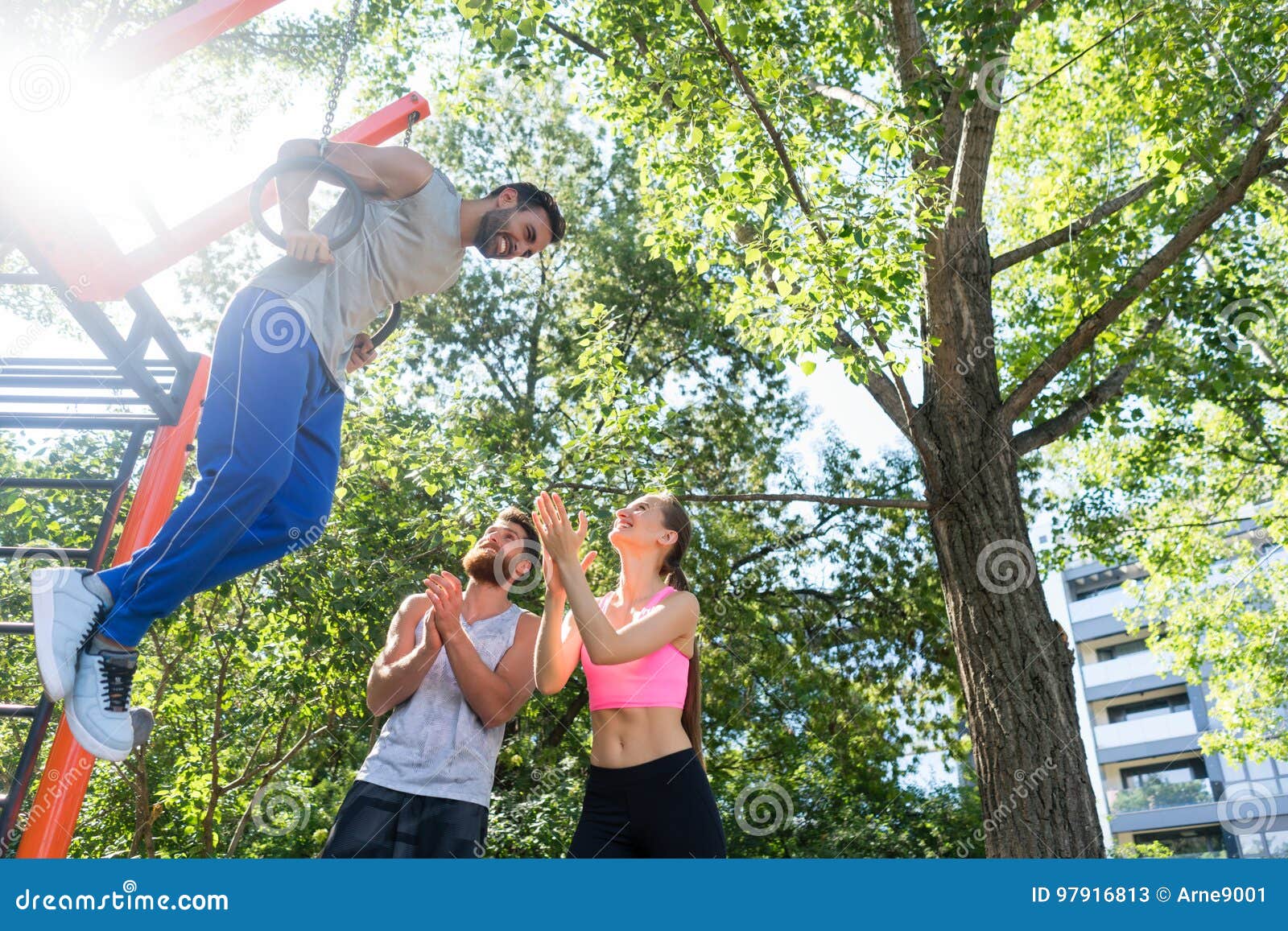 Young Man Doing Dip Exercise for Triceps on Gymnastic Rings at Street