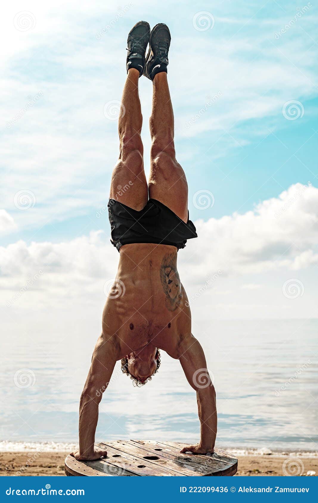 Young Man is Doing Street Workout. Handstand Exercise, Bodyweight Stock