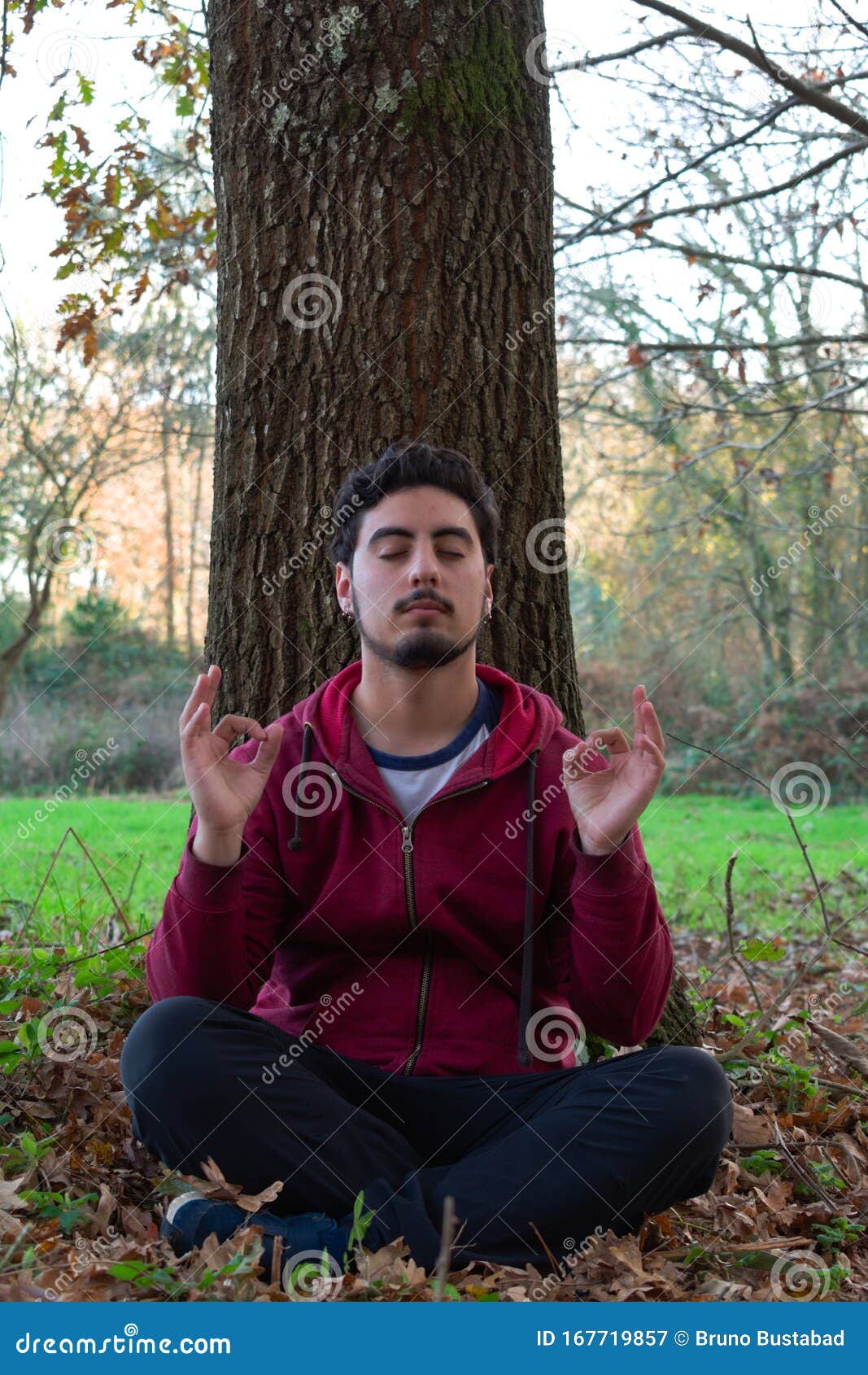 Young Man Doing Yoga and Meditating in the Middle of the Forest ...