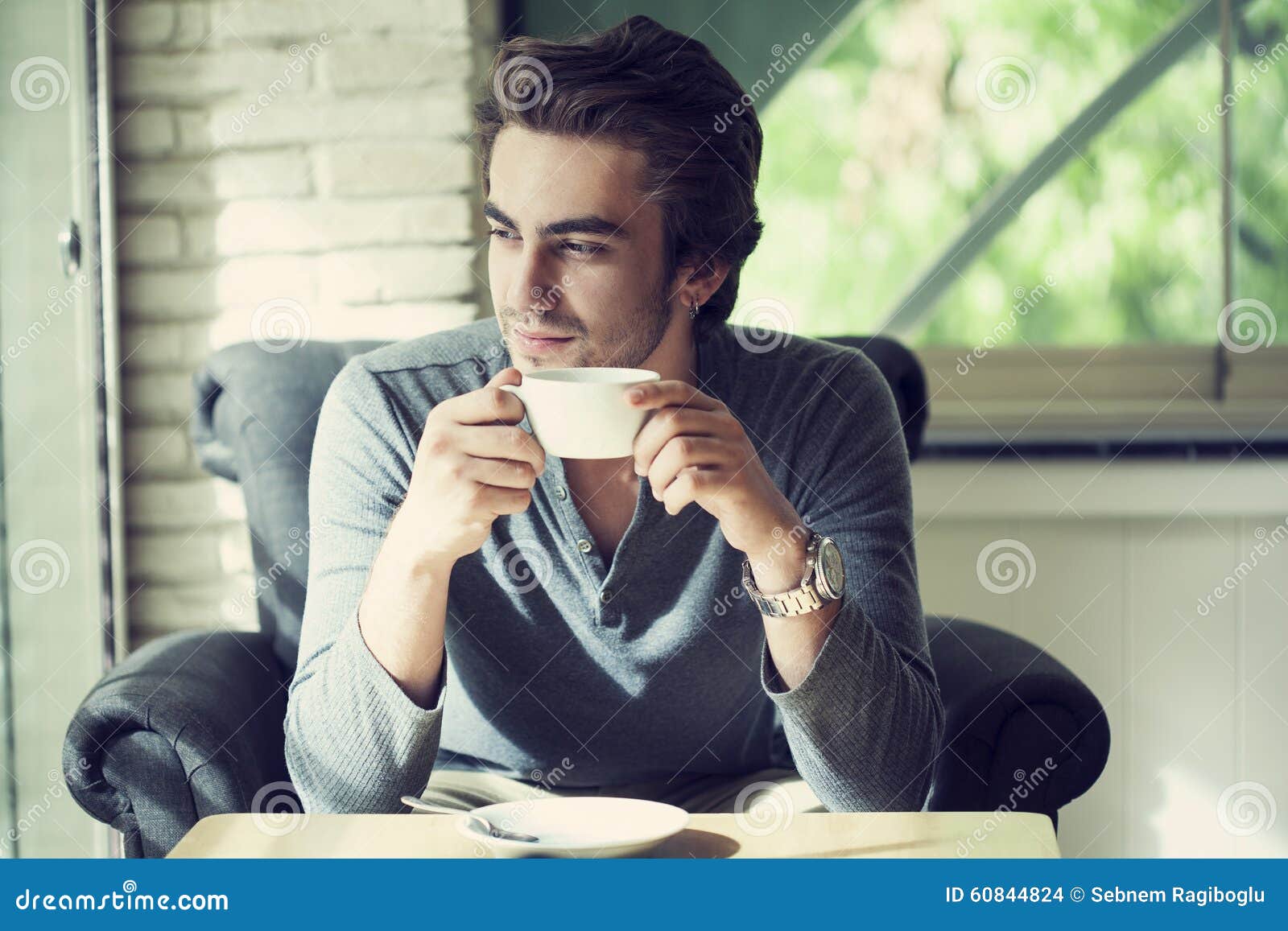 young man drinking coffee in cafe