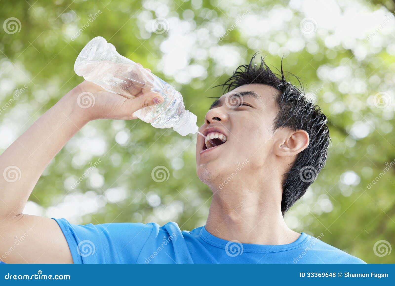 Young Man Drinking Water Bottle In Park Stock Photo Image Of