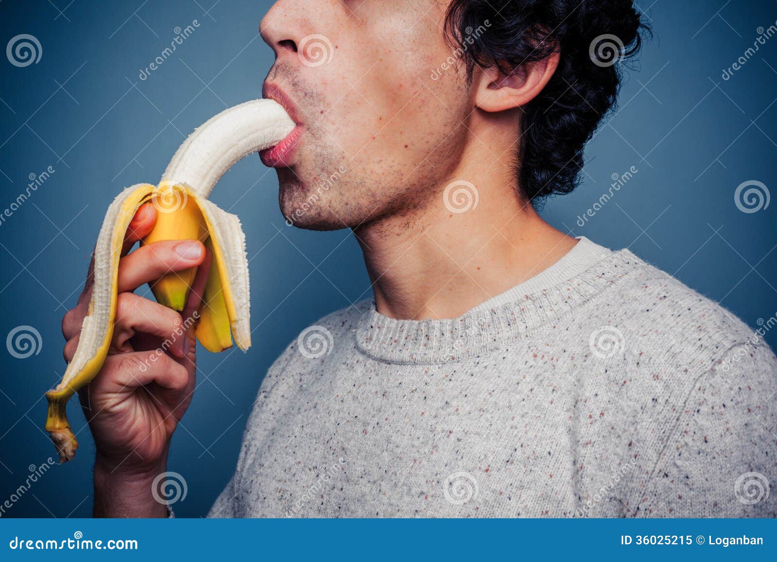 young-man-eating-banana-multi-racial-36025215.jpg