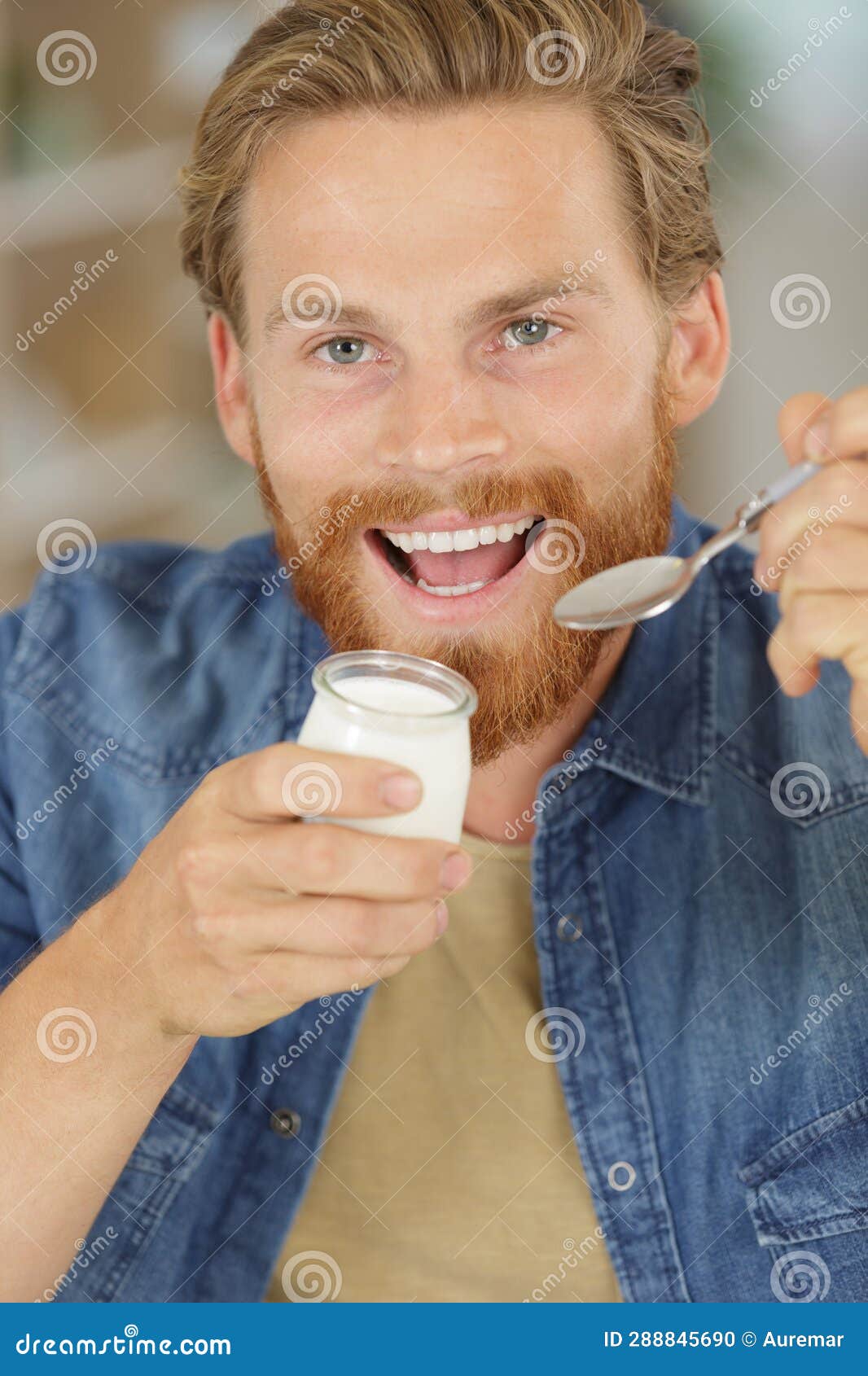 Young man eating yogurt stock photo. Image of food, milk 288845690