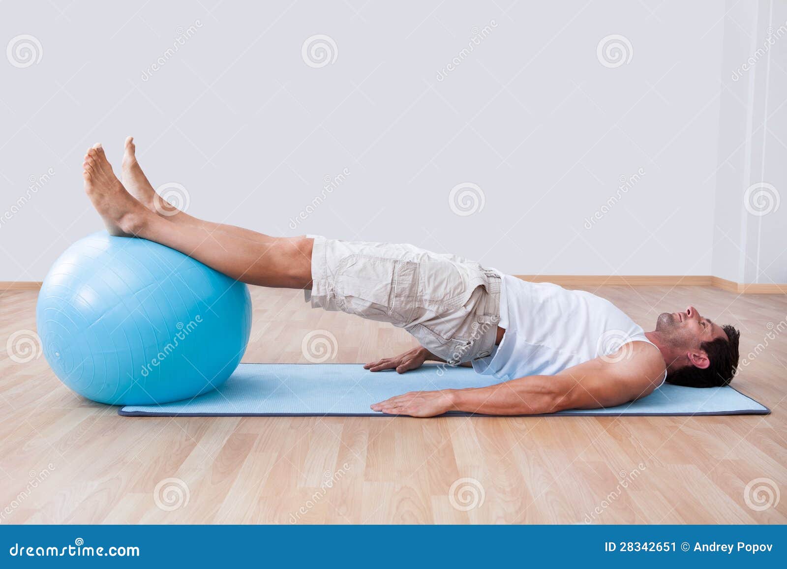 young man exercising on a pilates ball