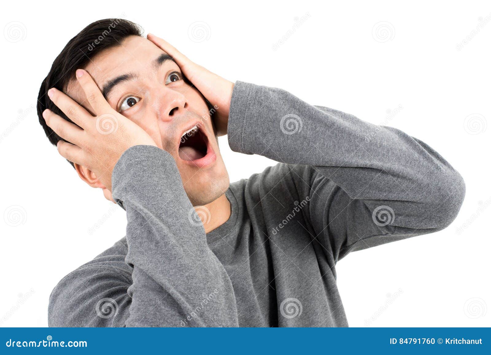 young man expressing shocked face with hands on head