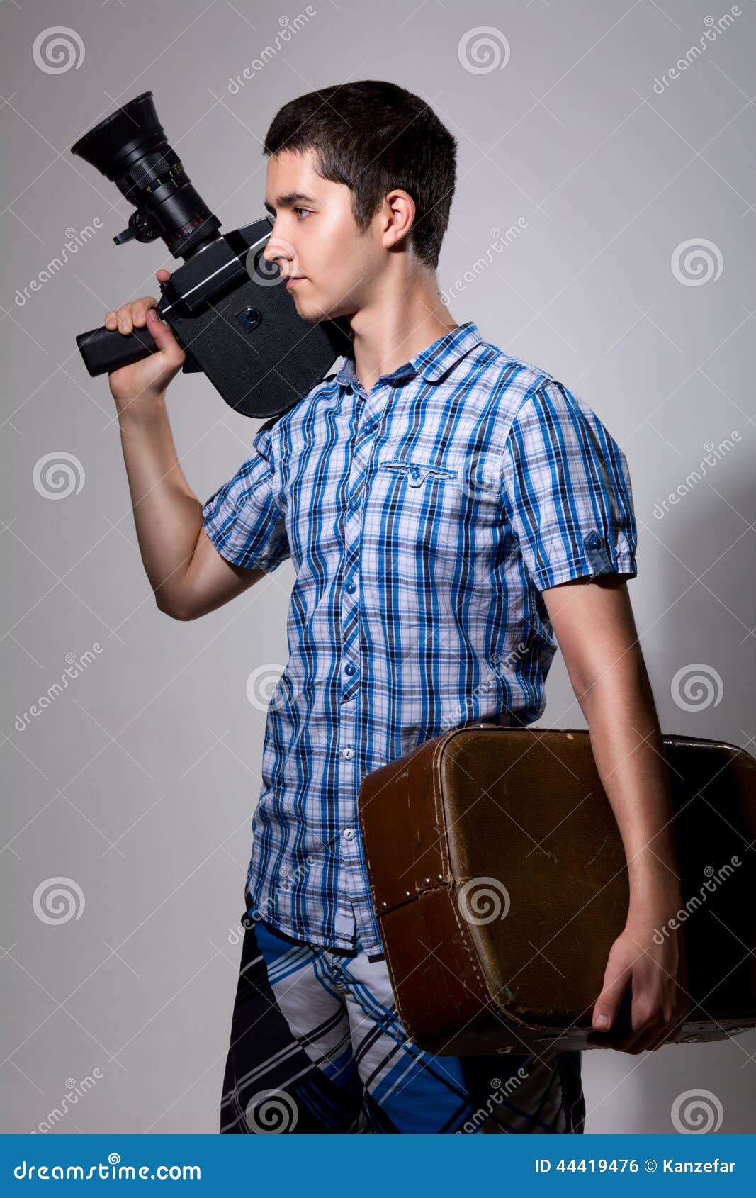 Young Man Filmmaker with Old Movie Camera and a Suitcase in His Stock Photo Image of people