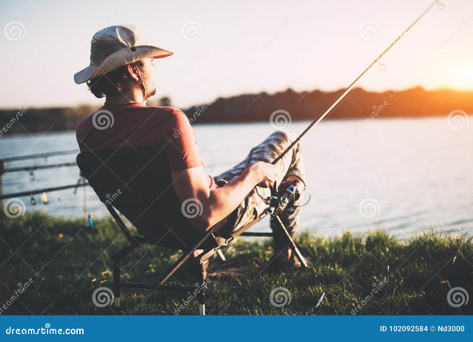 young man fishing at pond and enjoying hobby
