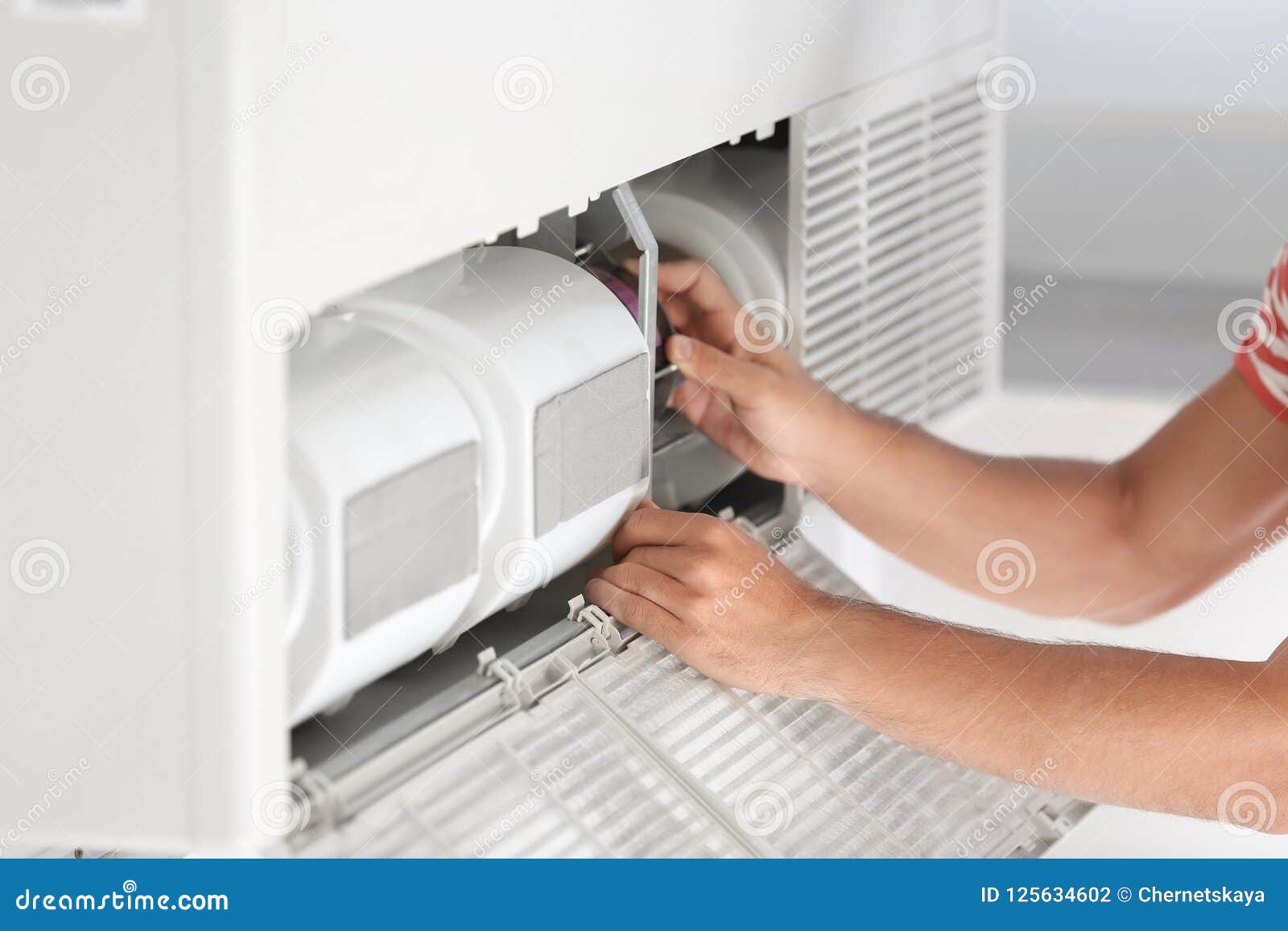 young man fixing air conditioner at home