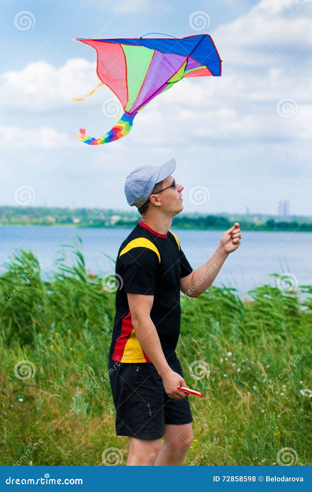 Young Man with Flying Kite stock photo. Image of recreation 72858598