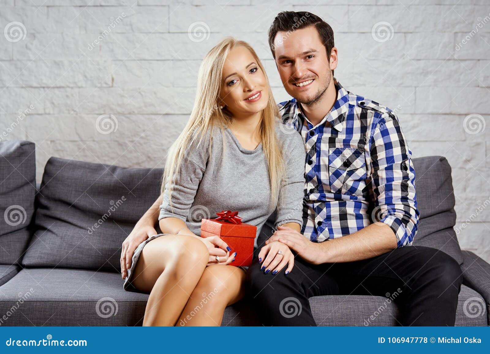 Couple embracing each other while kneeling on bed at home stock photo
