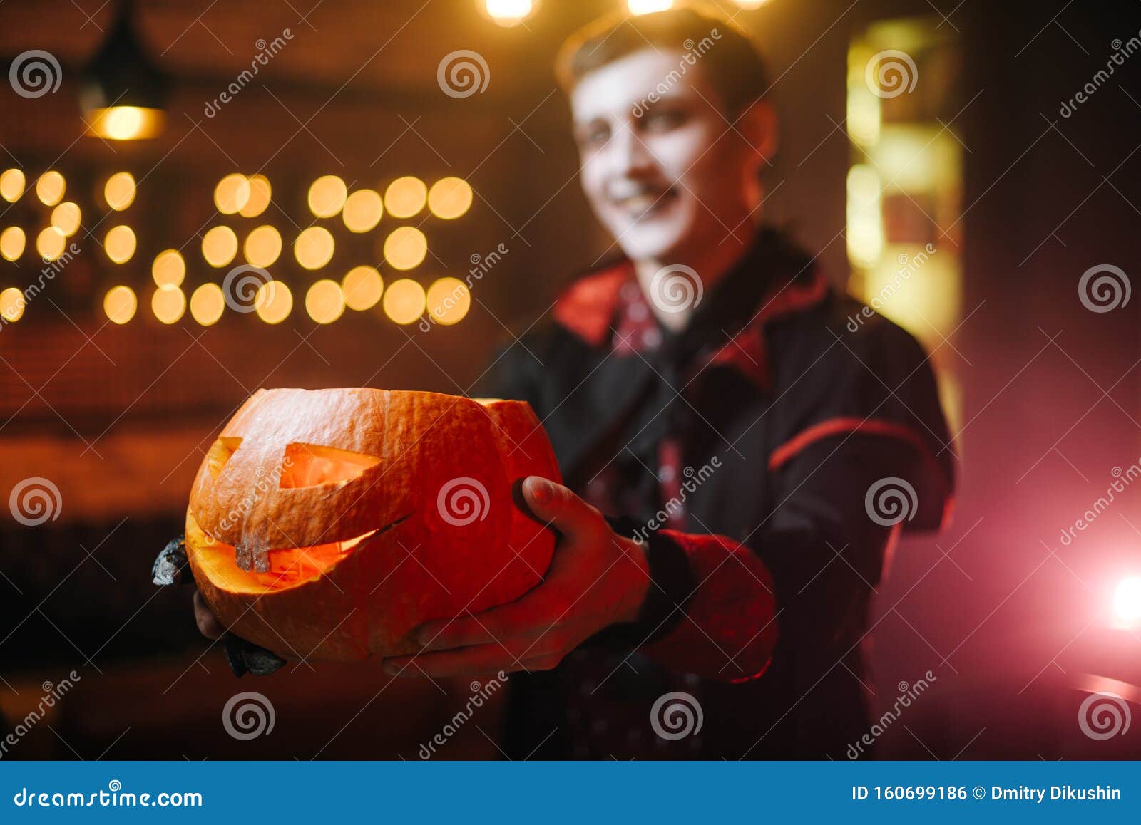 Young Man in a Halloween Costume of Count Dracula Holds a Carved ...