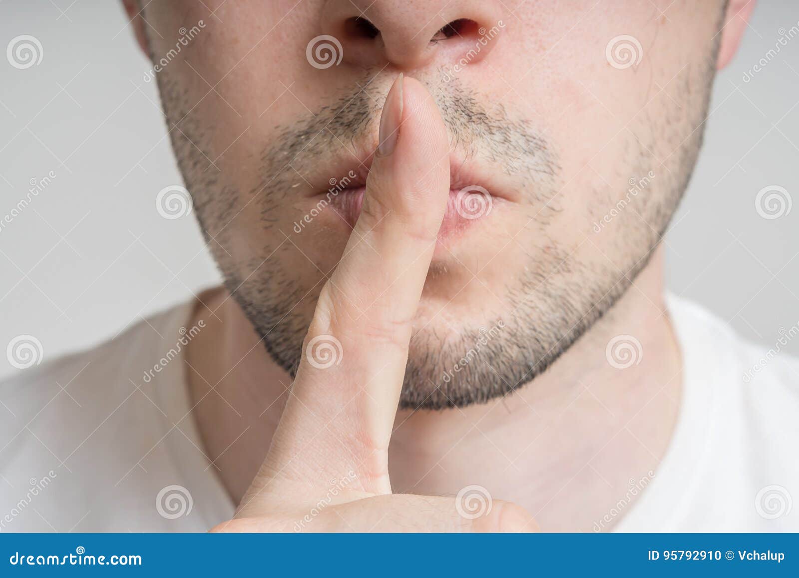 young man has finger on lips and showing be quiet gesture