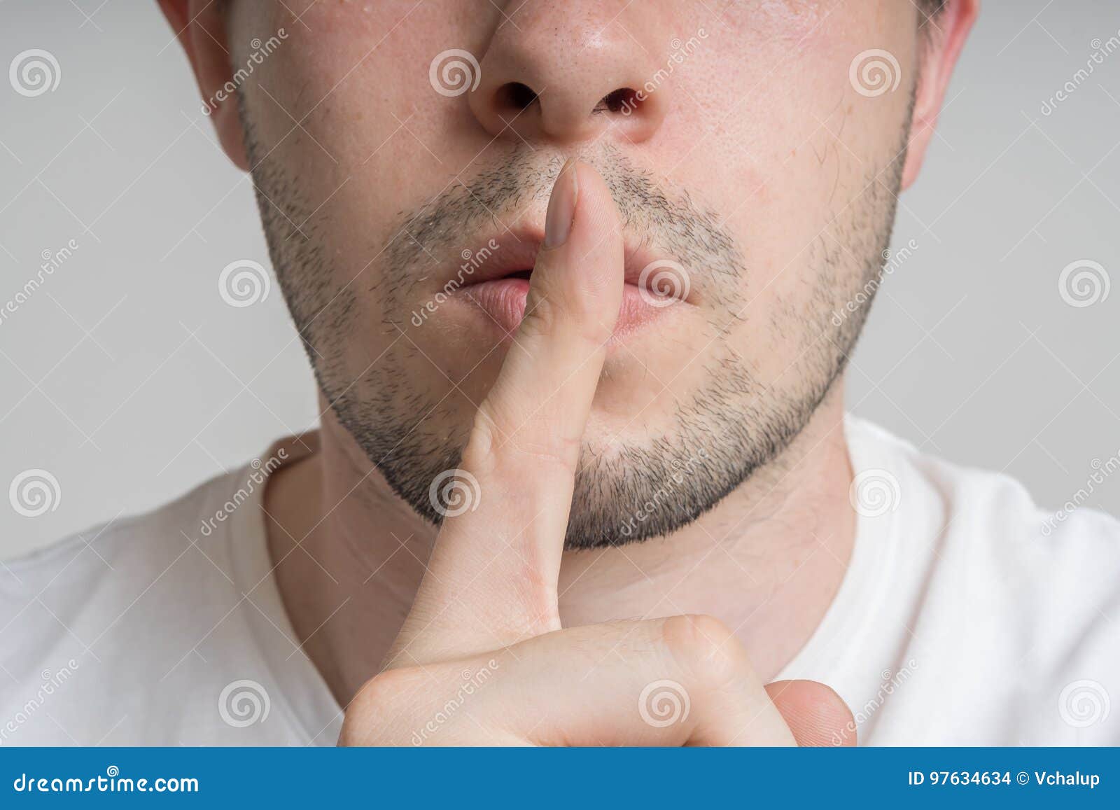 young man has finger on lips and showing be quiet gesture