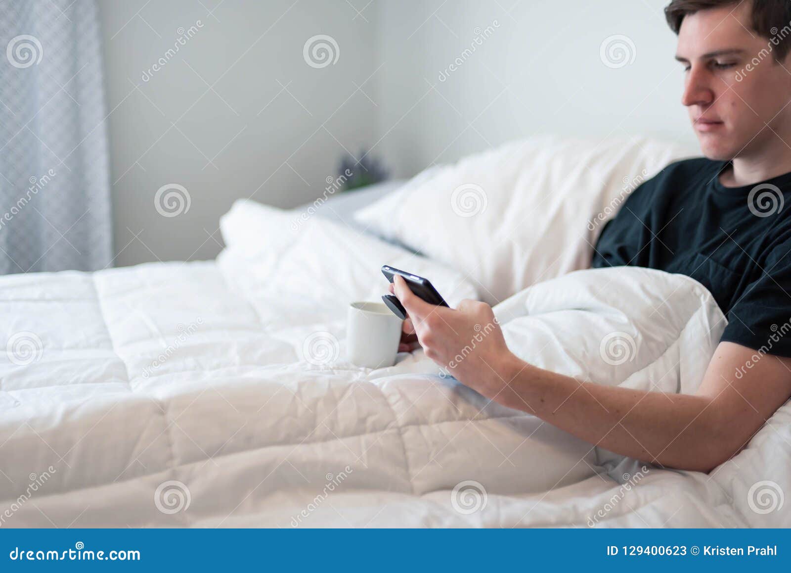 College Student Waking Up And Having Coffee In Bed Stock 