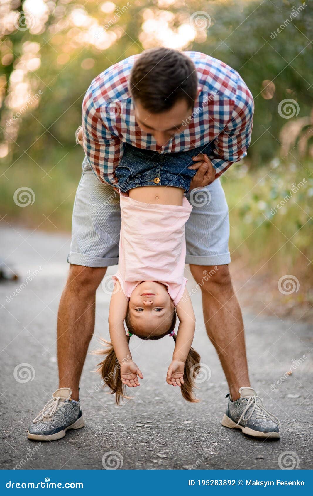 Young Man Having Fun with Little Girl and Hold Her Upside Down. Stock
