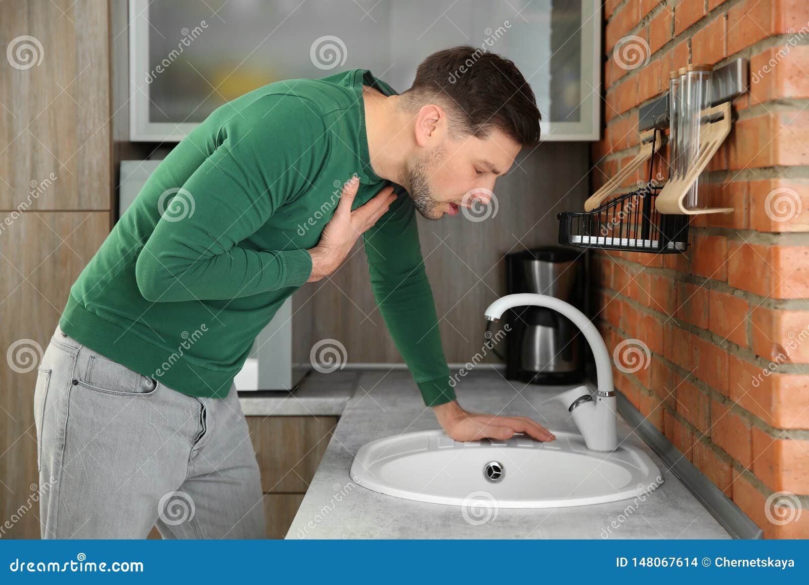 young man having nausea in kitchen