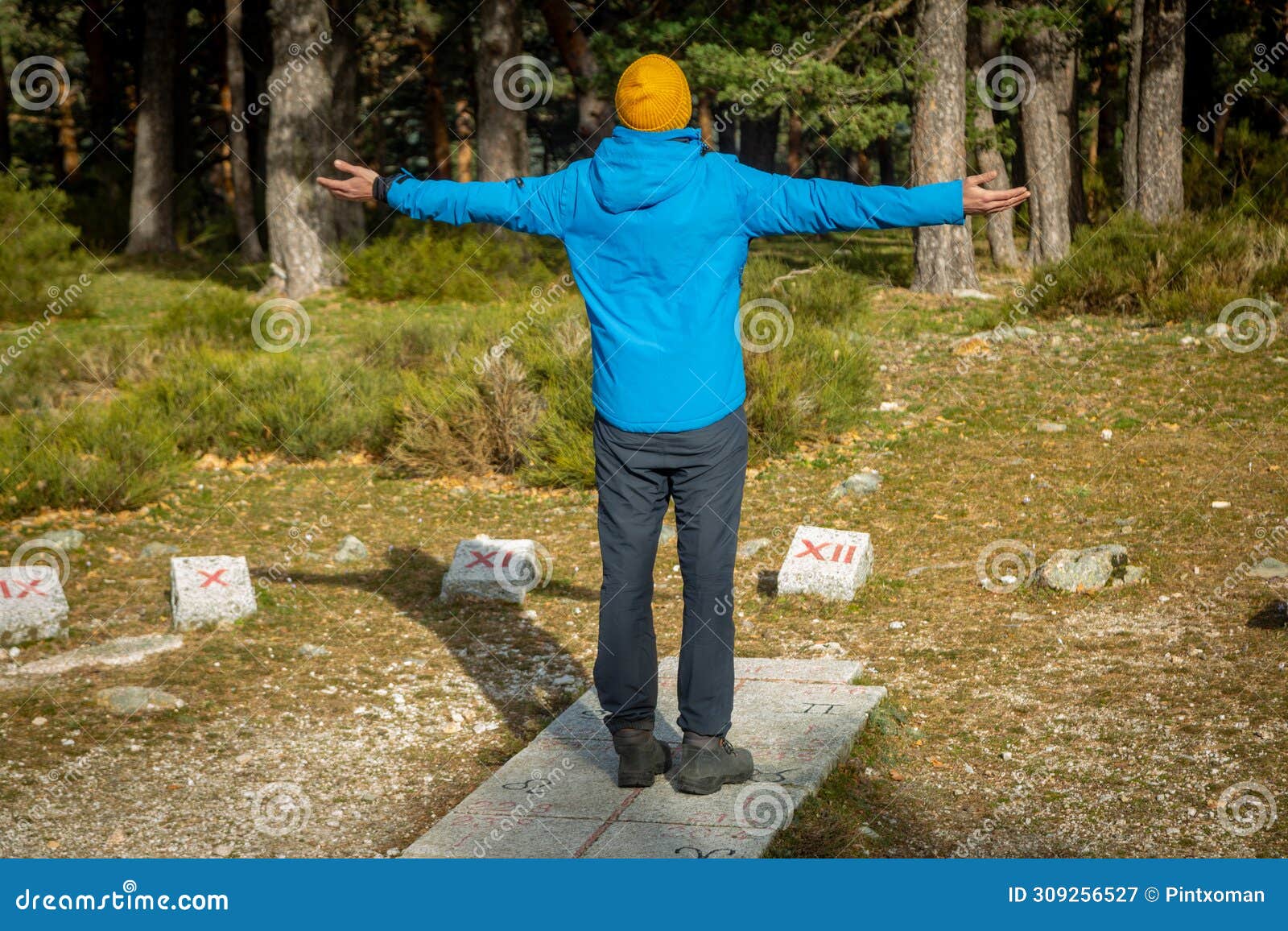 young man hiker with stone sundial in the middle of the forest in cercedilla, madrid