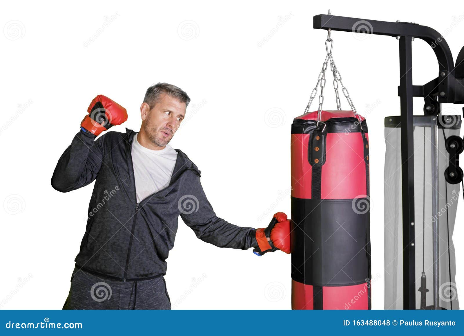 Young Man Hitting on a Boxing Bag in the Studio Stock Photo Image of
