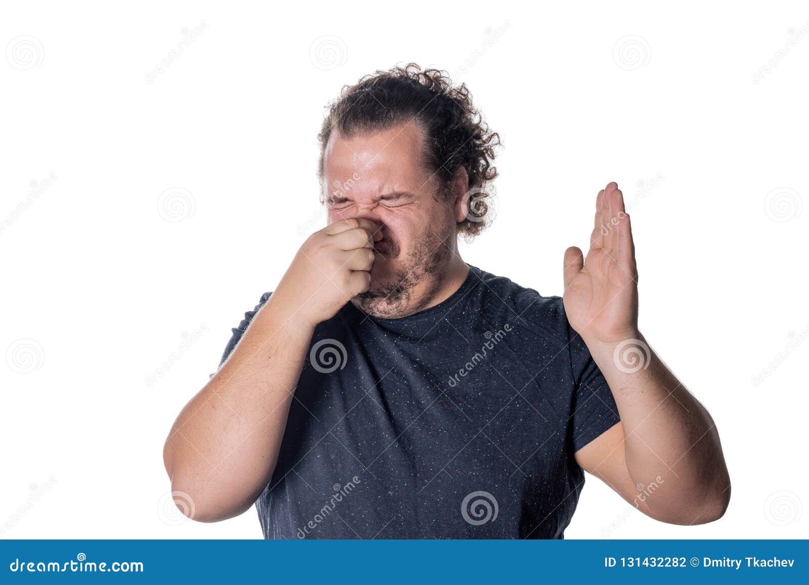 a young man holds or pinches his nose shut because of a stinky smell or odor.  on a white background
