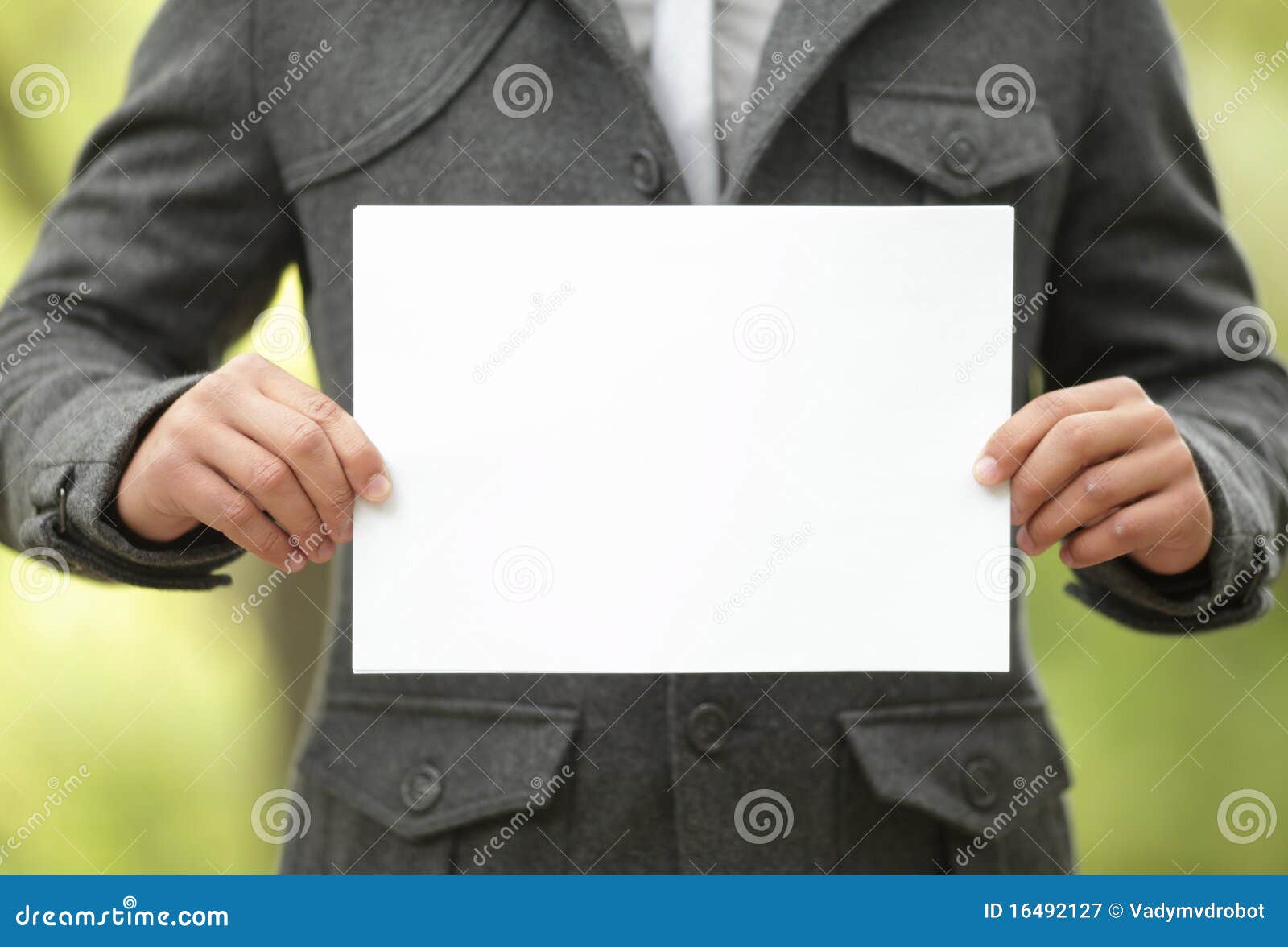 young man holds up a blank white sign