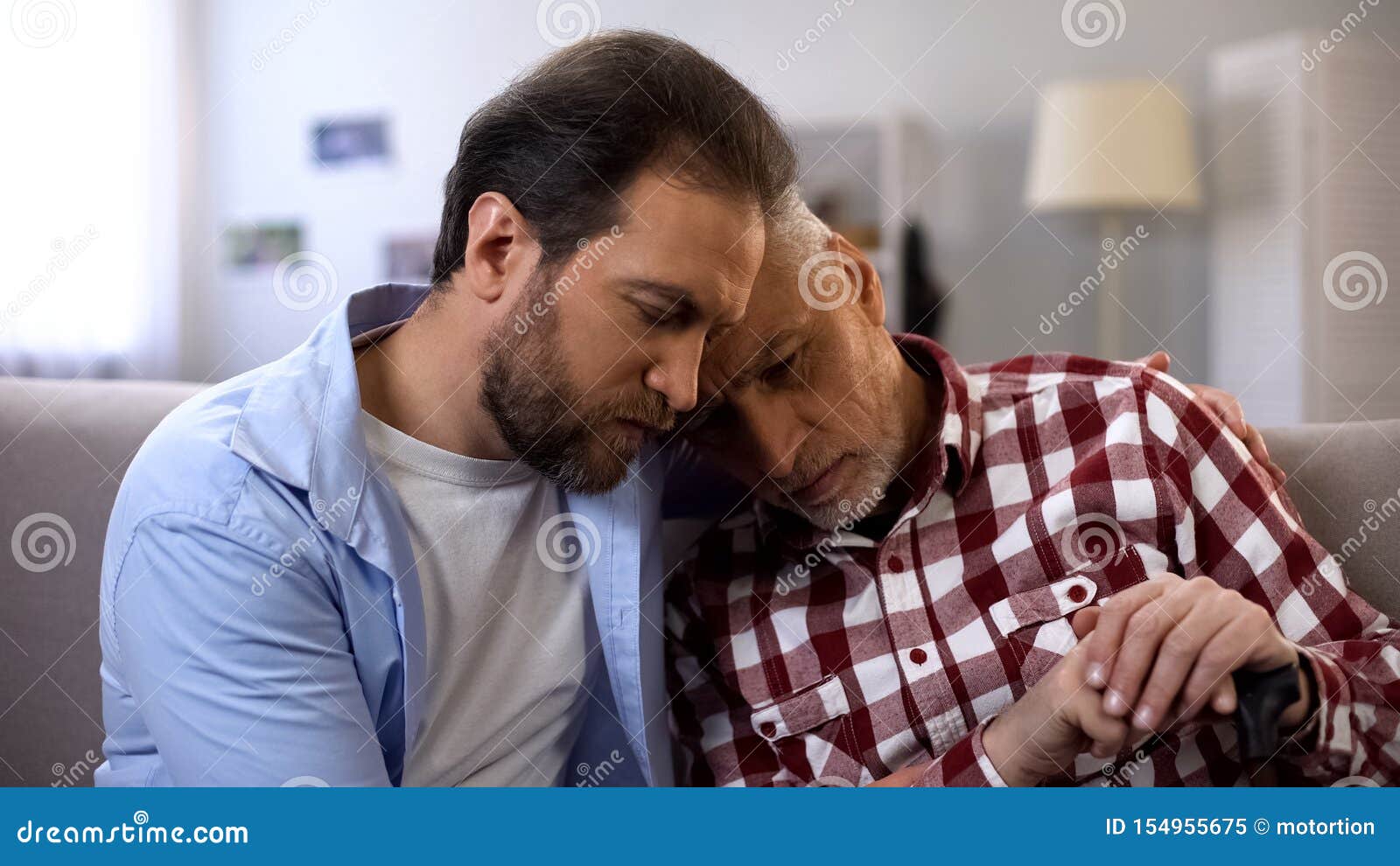 Young Man Hugging And Comforting Depressed Old Dad Suffering