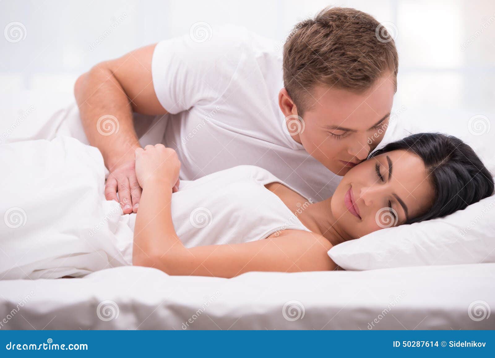 Young Man Kissing His Sleeping Wife Stock Photo picture Young Man Kissing His Sleeping Wife Stock Photo