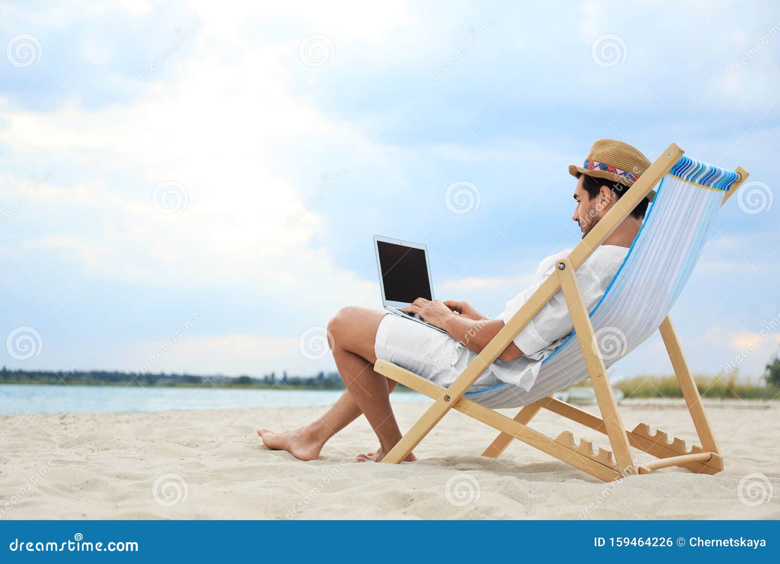 Young Man with Laptop Sitting in Deck Chair on Sea Beach Stock Photo ...