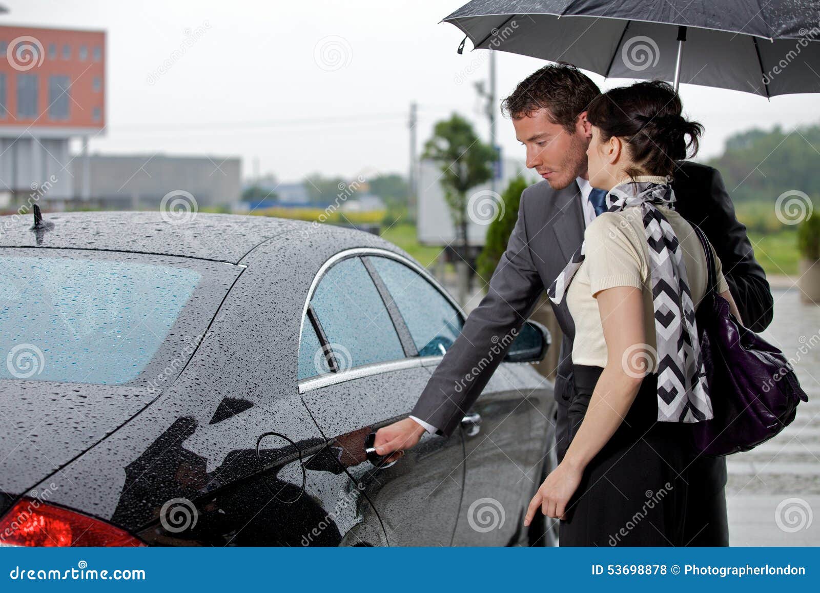 young man opening door of car for woman