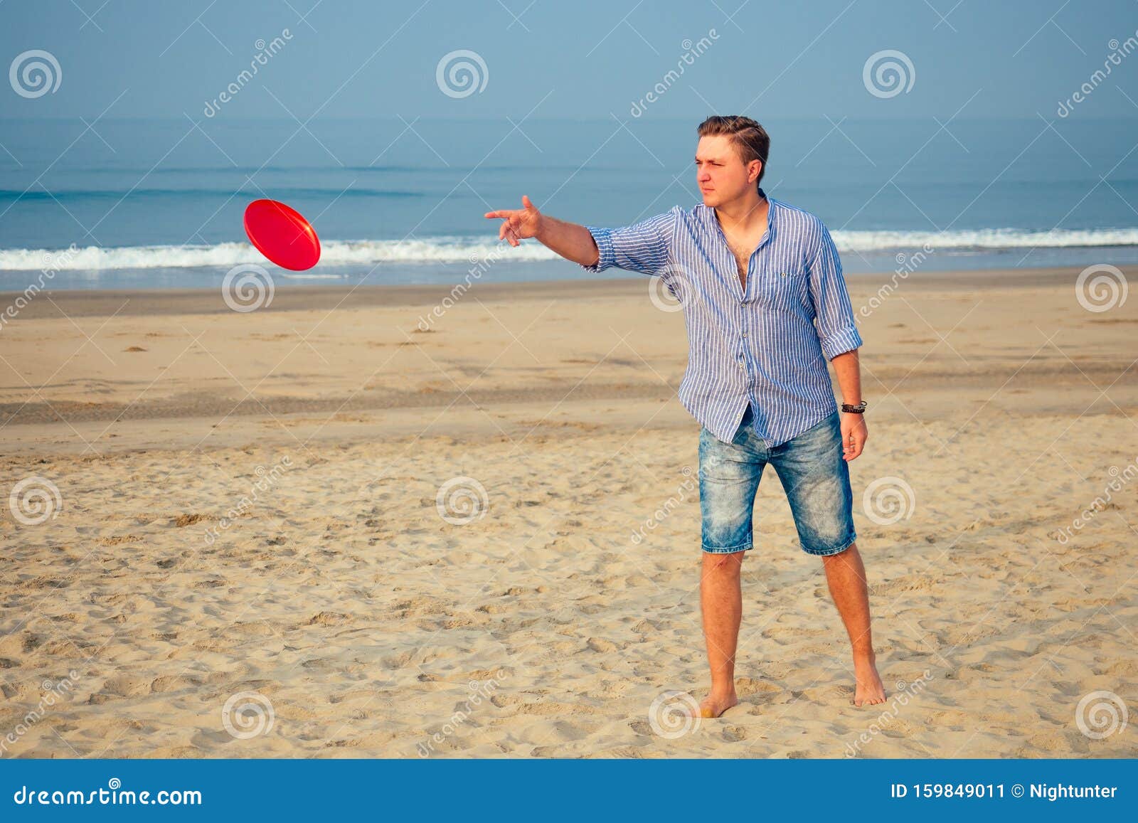 Young Man Playing Flying Disk with Friends on the Beach Stock Image