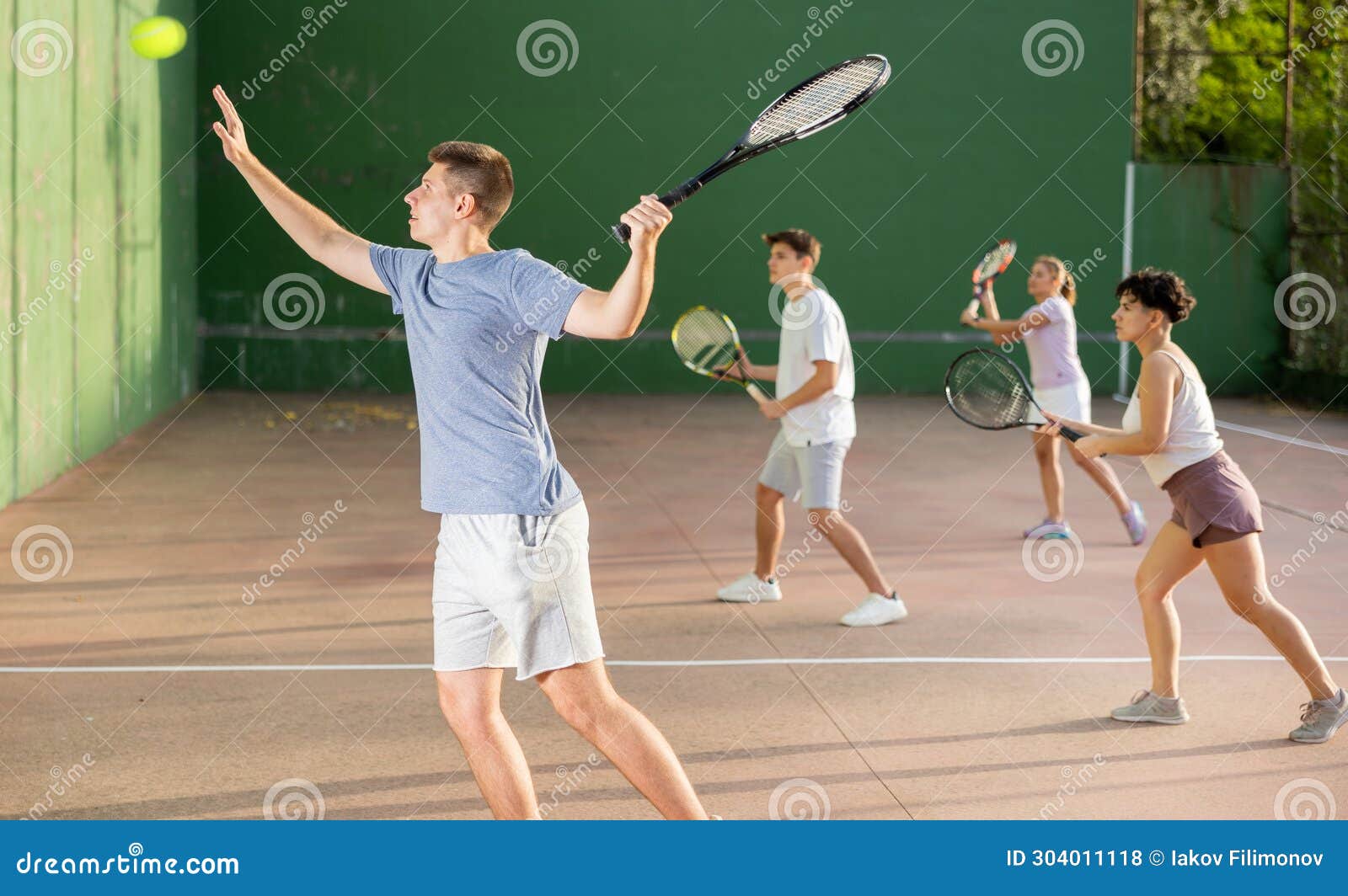 young man playing frontenis on outdoor pelota court