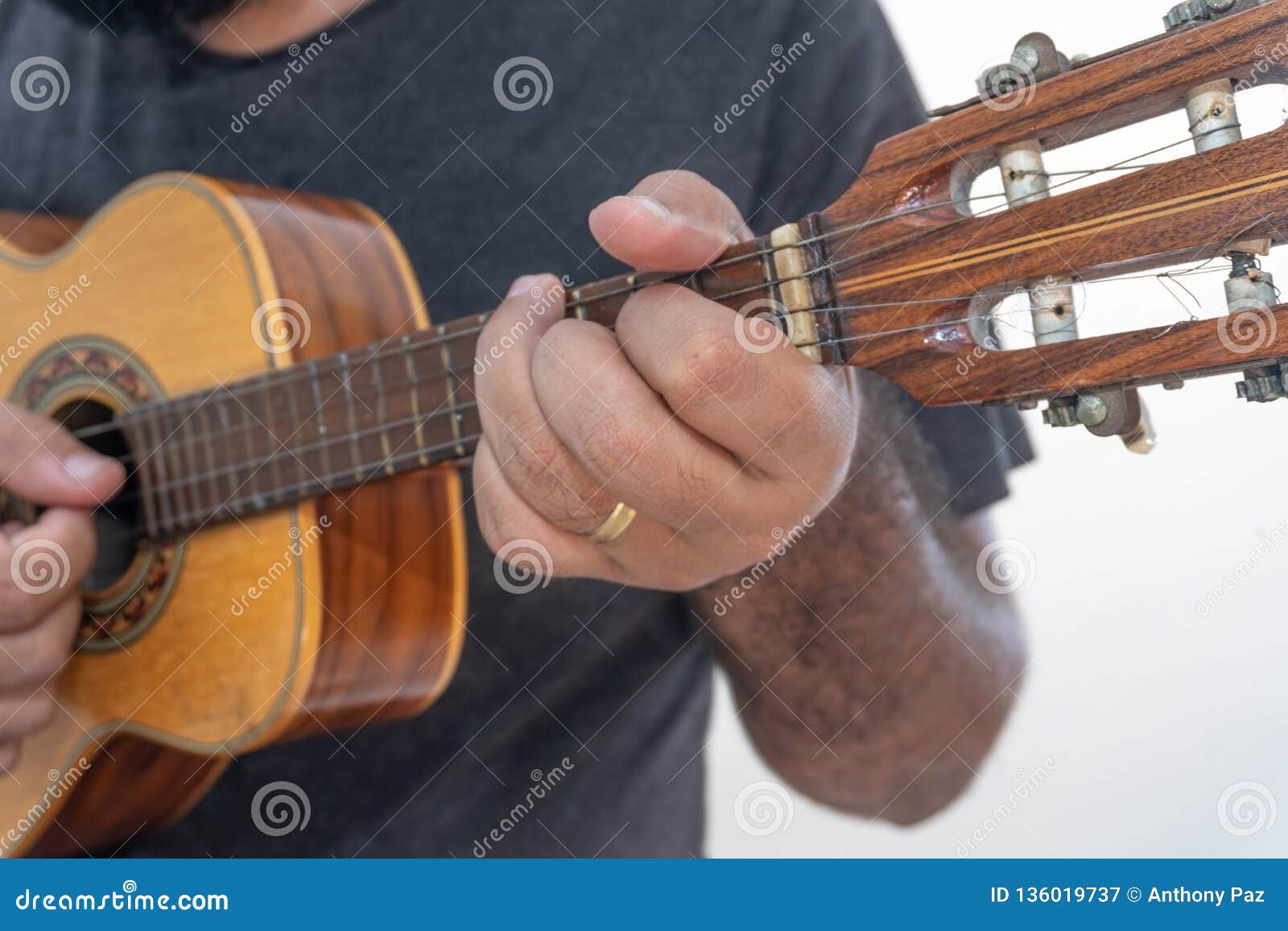 young man playing ukulele with shirt and black pants