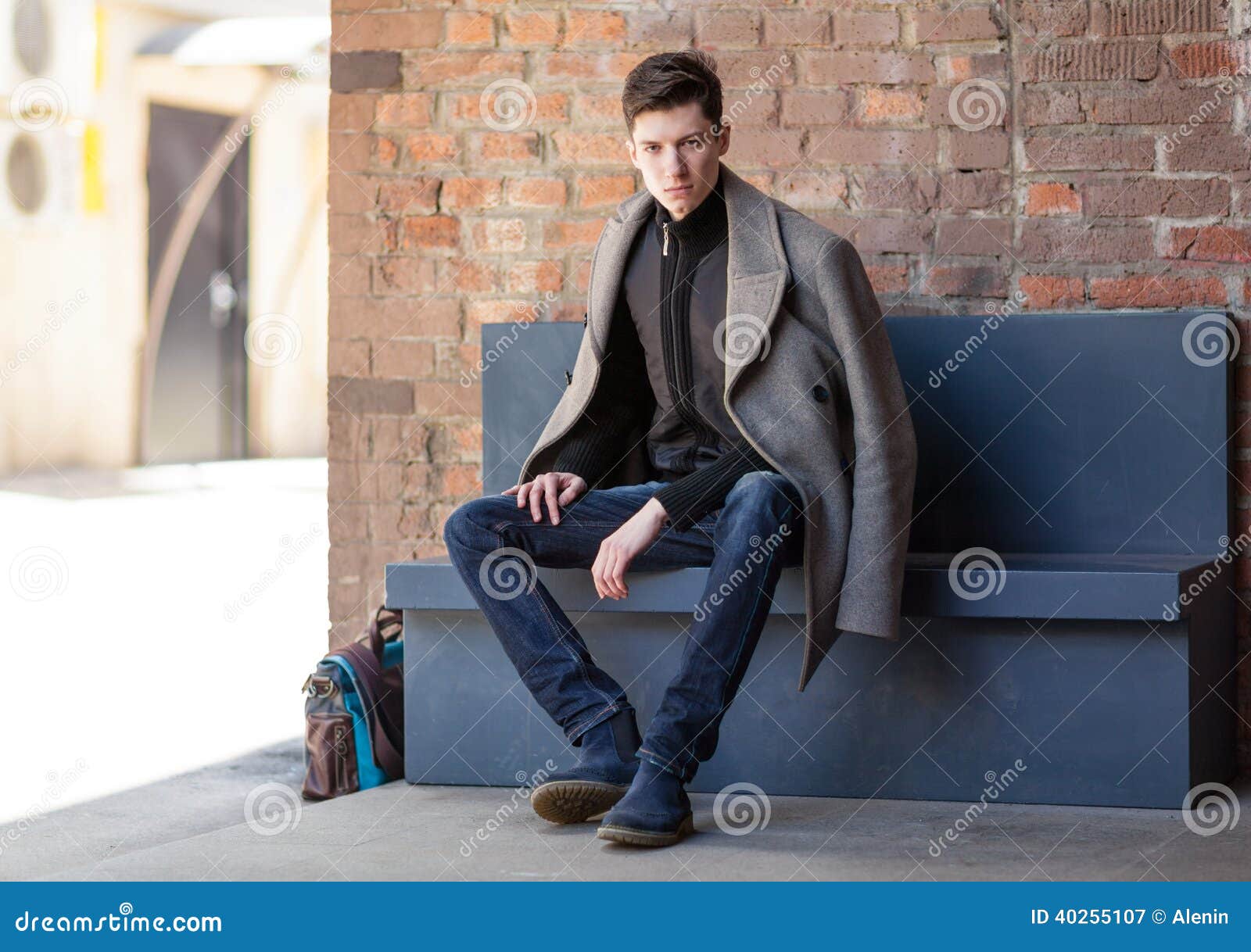 outerwear, trendy man in glasses and trench coat posing on grey backdrop,  cozy layers, fall fashion Stock Photo by LightFieldStudios