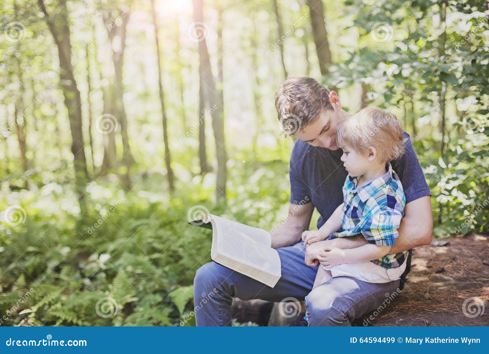 young man reading bible to child