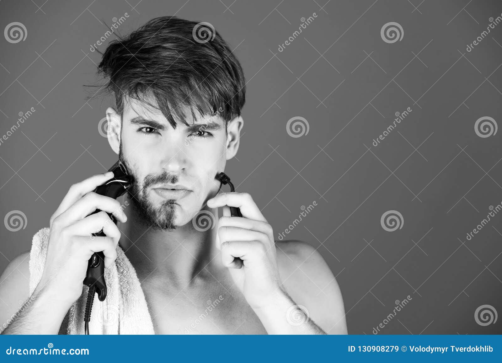 young man shaving face hair with safety razor and electric shaver