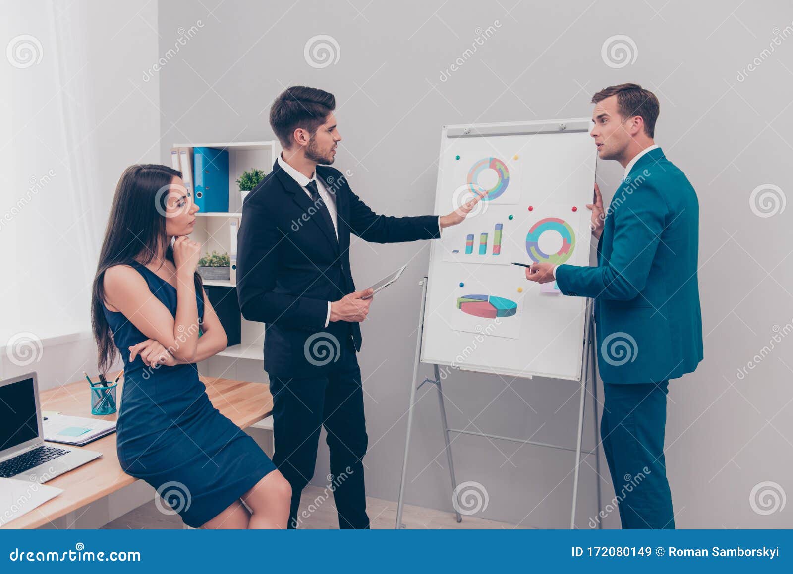 young man showing diagrama on flipchart to his colleagues