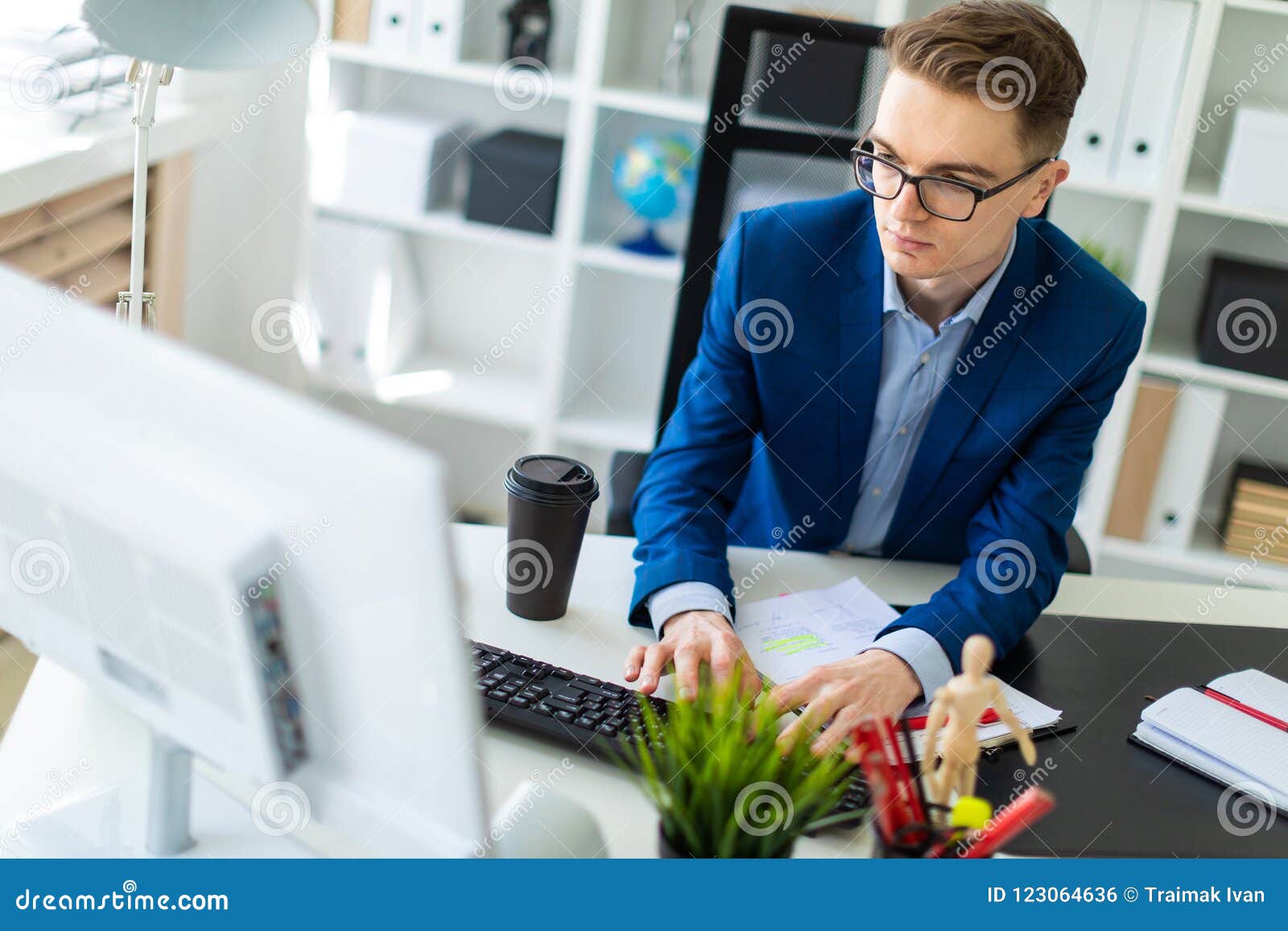 A Young Man Sits At A Table In The Office And Works With Documents