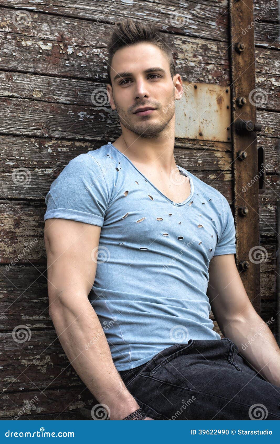 Young Man Sitting Against Old Wood Wall Stock Photo - Image of male ...