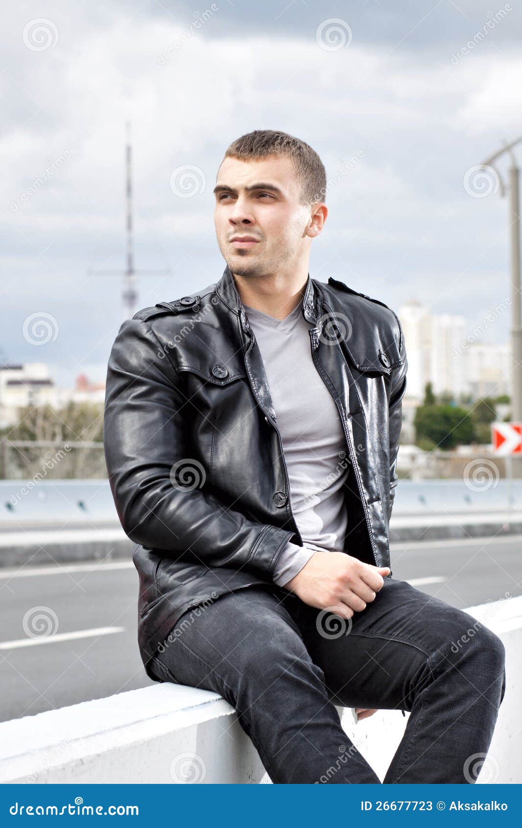 young man sitting alongside a roa