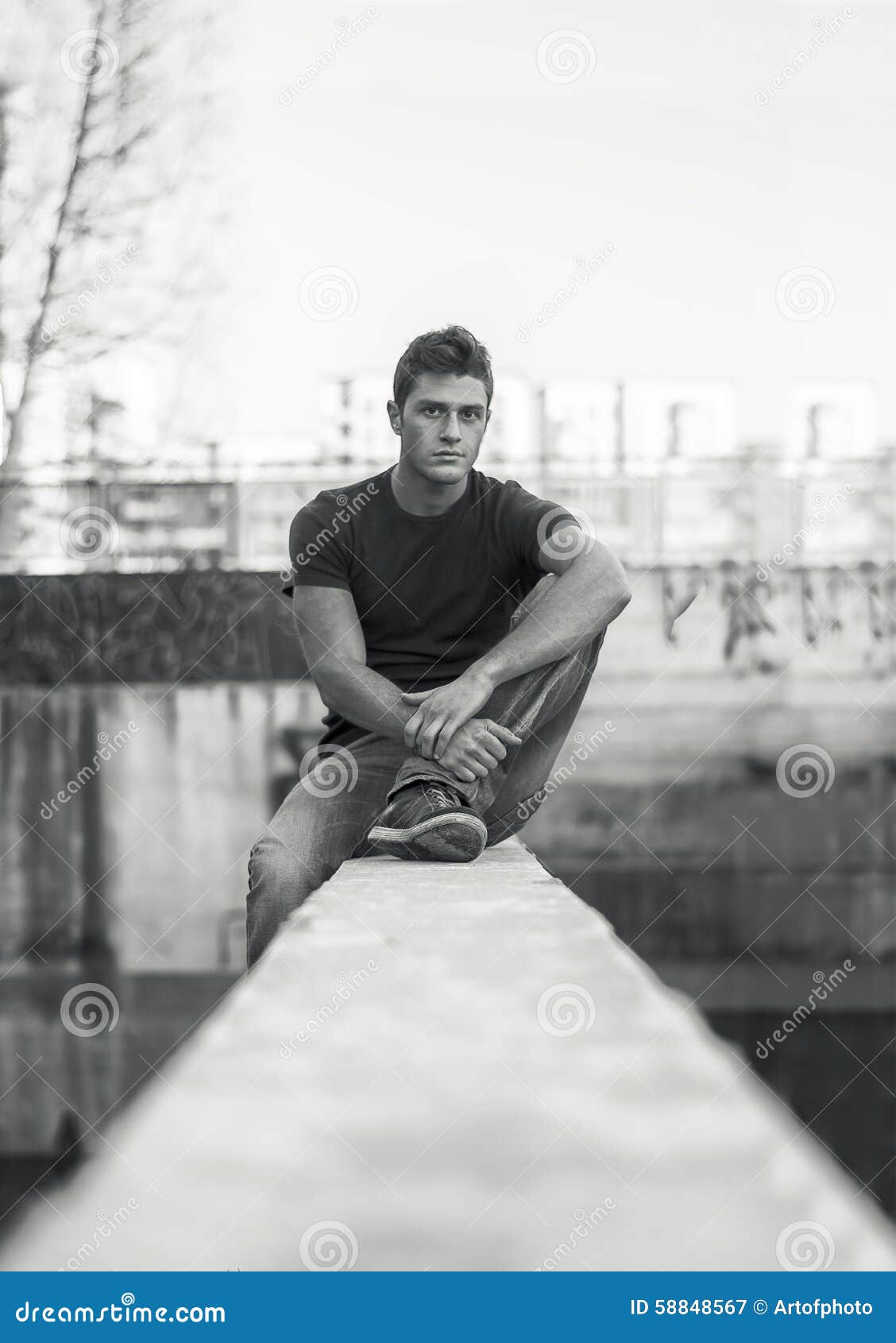 Young Man Sitting on Dirty Wall, Looking at Camera Stock Image - Image ...