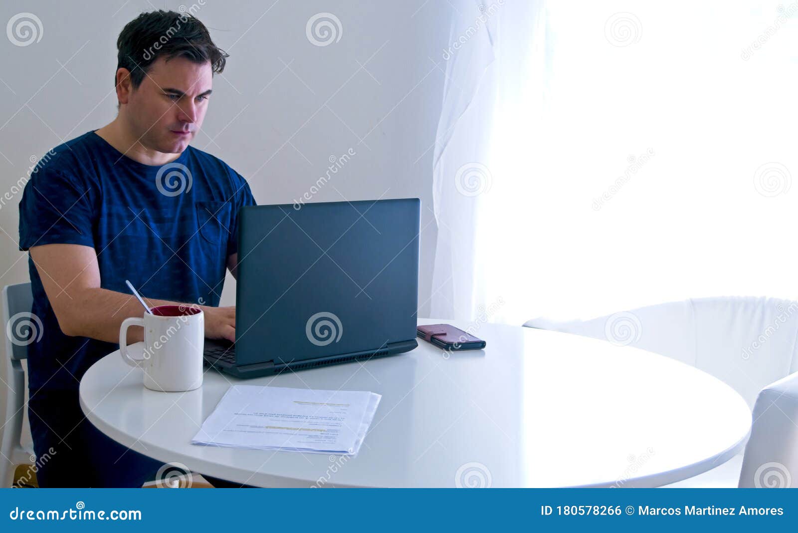 young man sitting and working on laptop at home. working father concept. teleworking concept