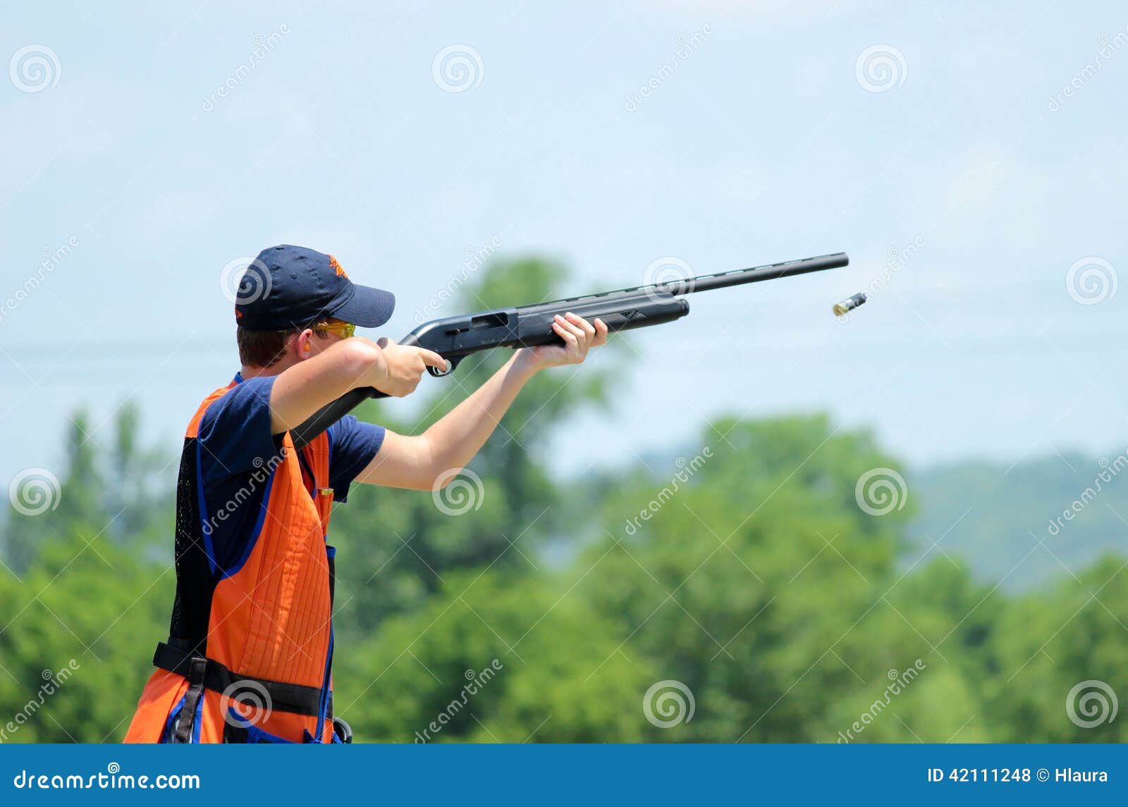 young man skeet shooting with airborne shell