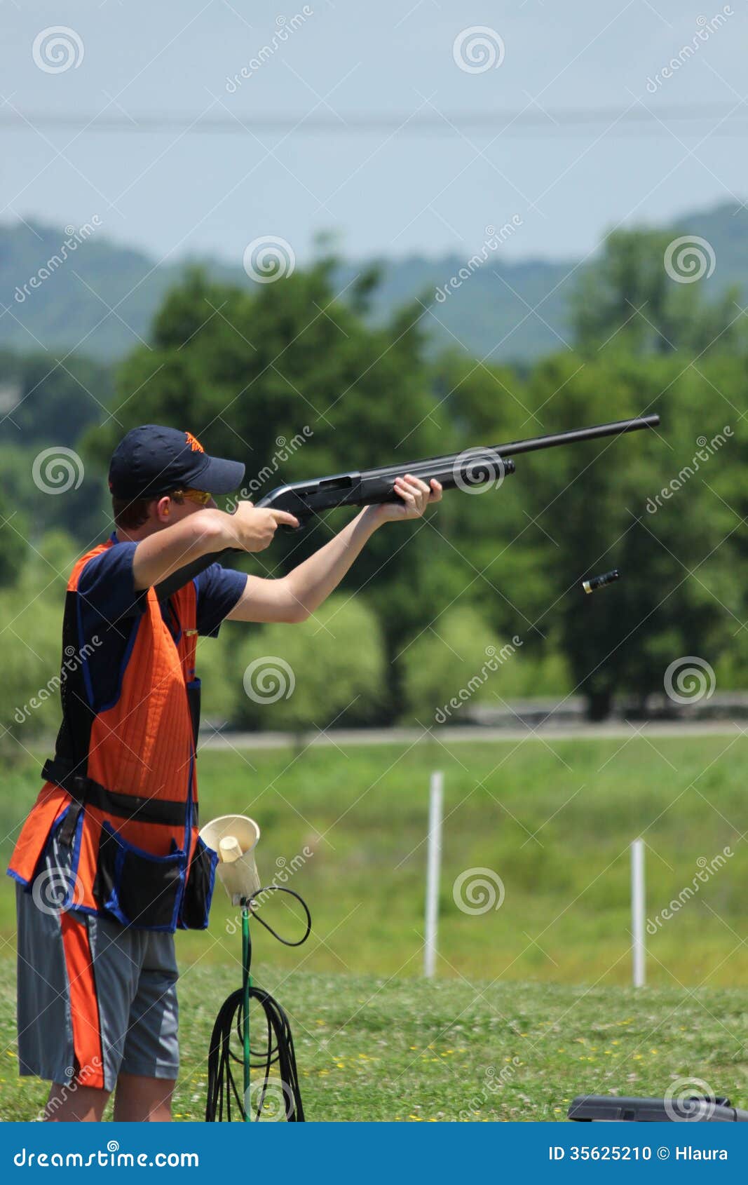 young man skeet shooting with airborne shell