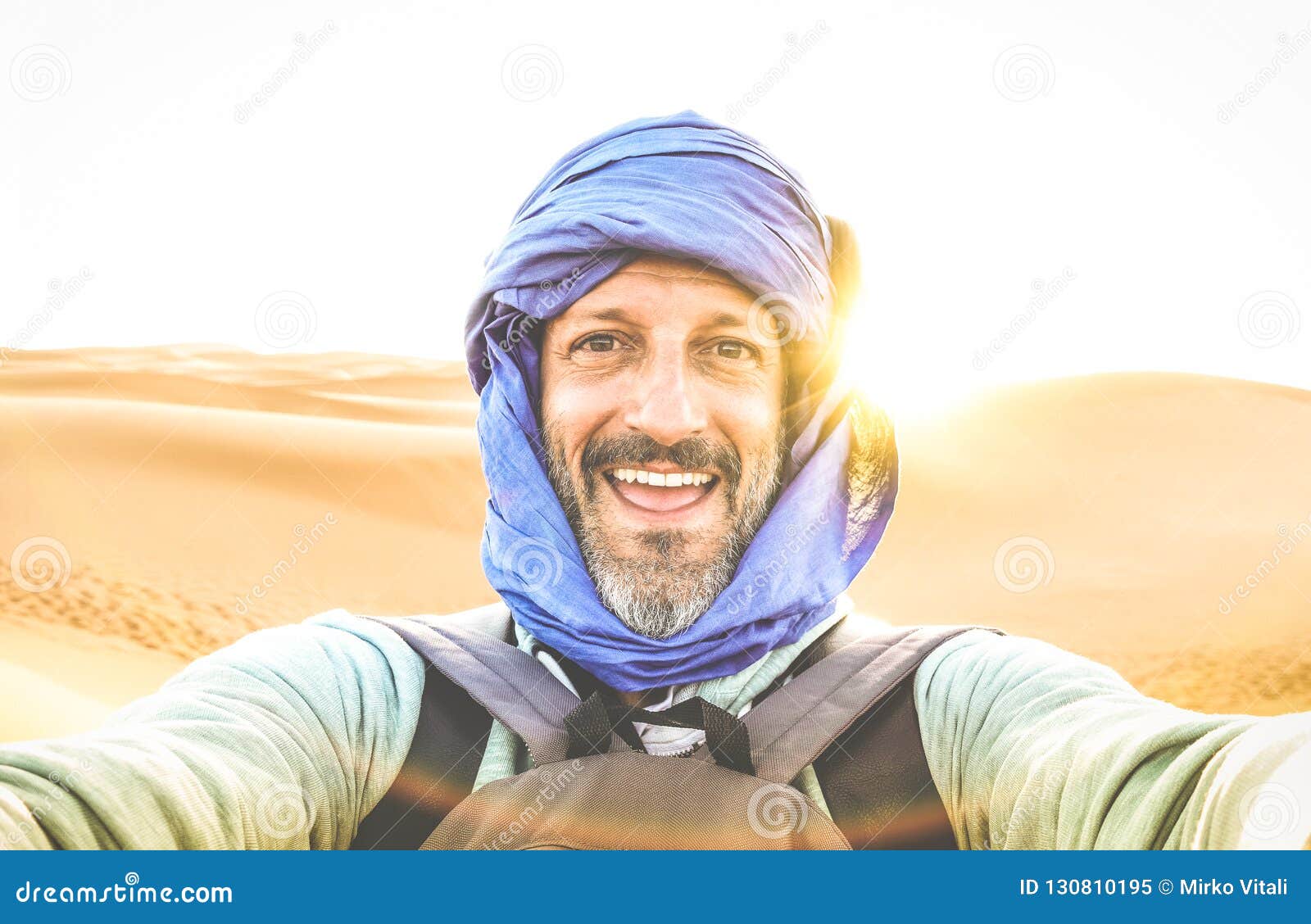 young man solo traveler taking selfie at erg chebbi desert dune