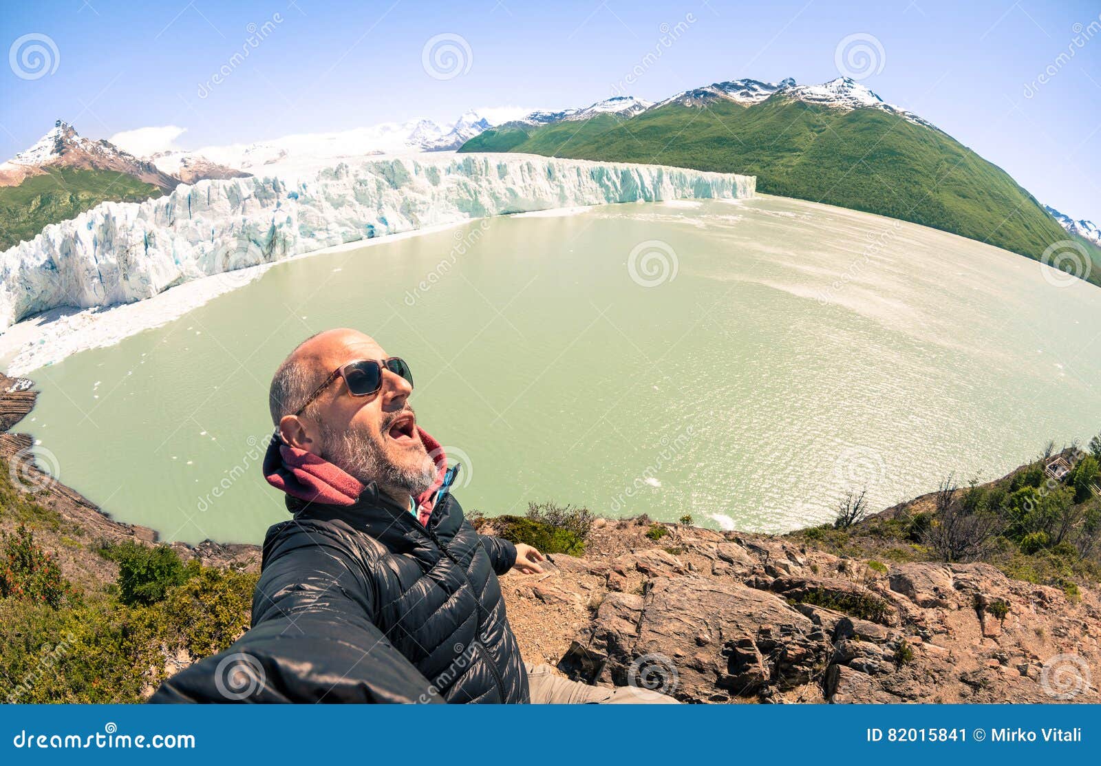 young man solo traveler taking selfie at perito moreno glaciar