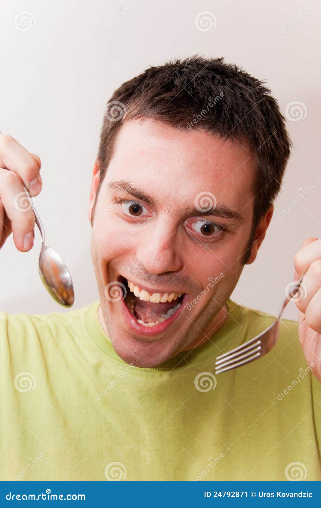 Young man with spoon and fork