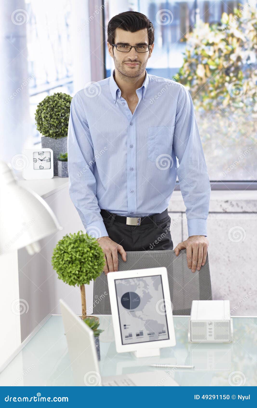 Young man standing by desk stock photo. Image of european 49291150